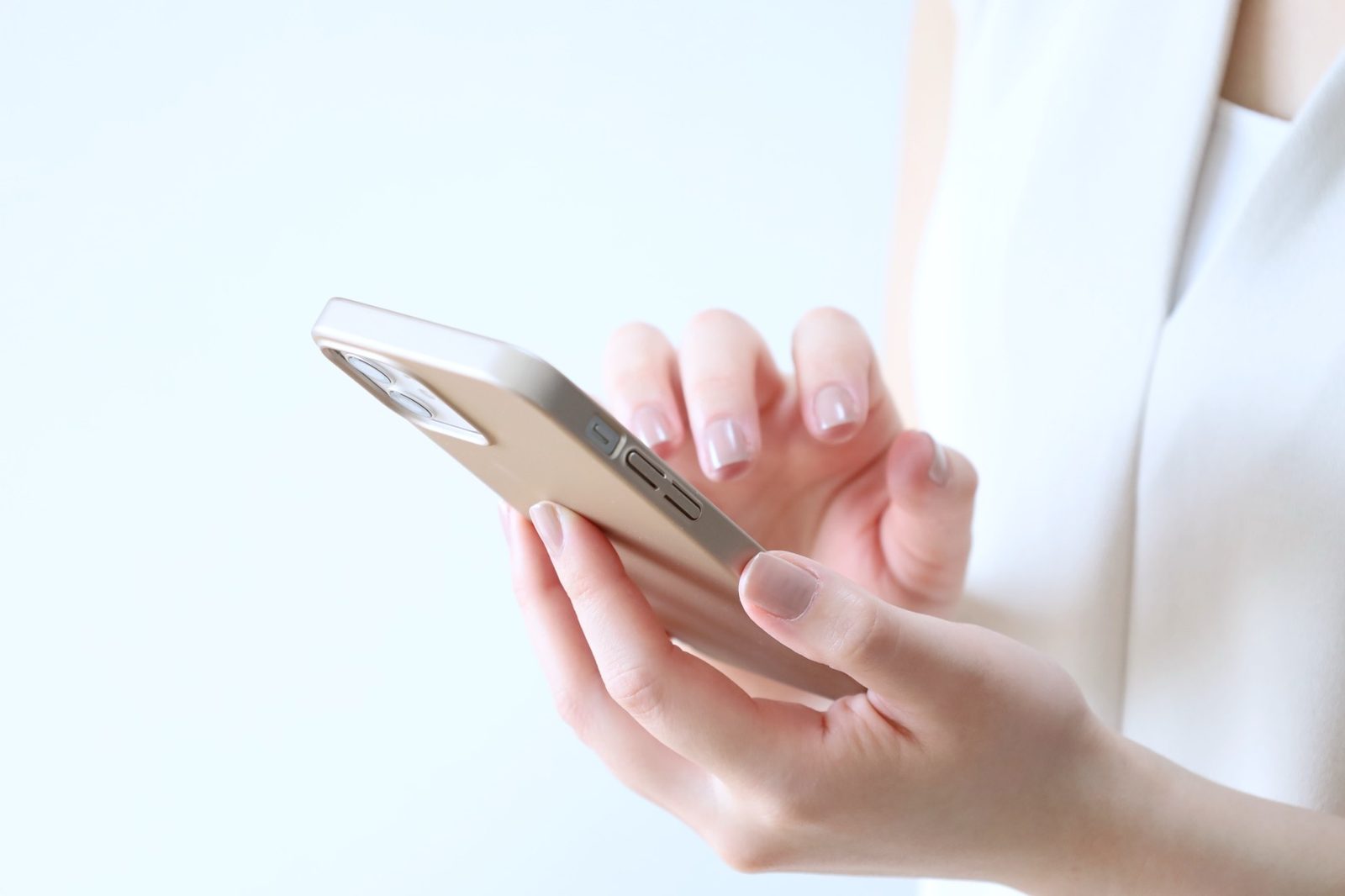 明るい光のなかでスマートフォンを操作する手元